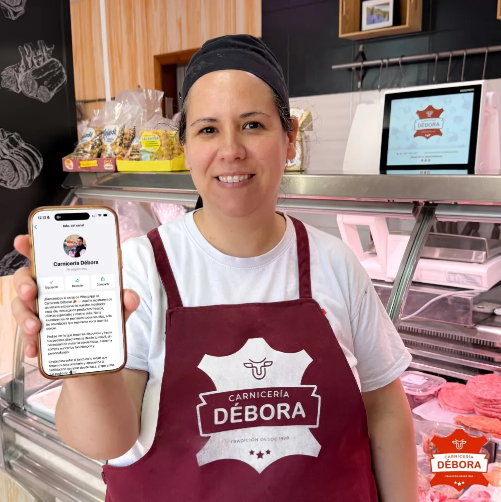 Carnicera mostrando en el móvil el canal de WhatsApp de Carnicería Débora